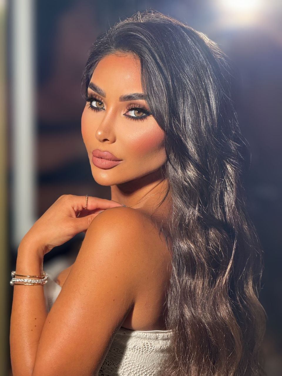 Zina Almokri glancing over her shoulder in warm golden light