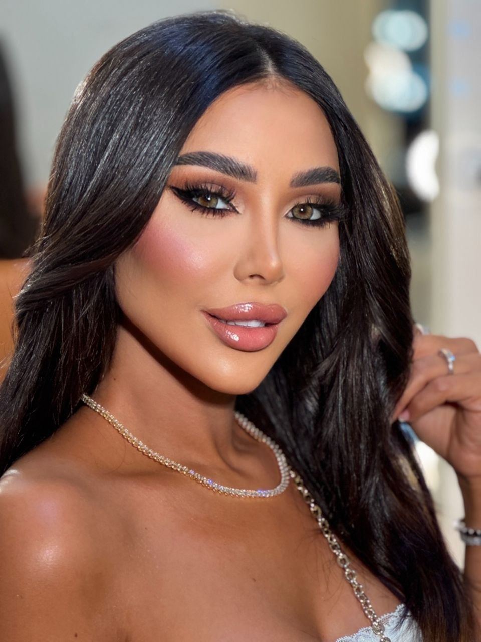 Zina Almokri smiling softly in a bright close-up portrait