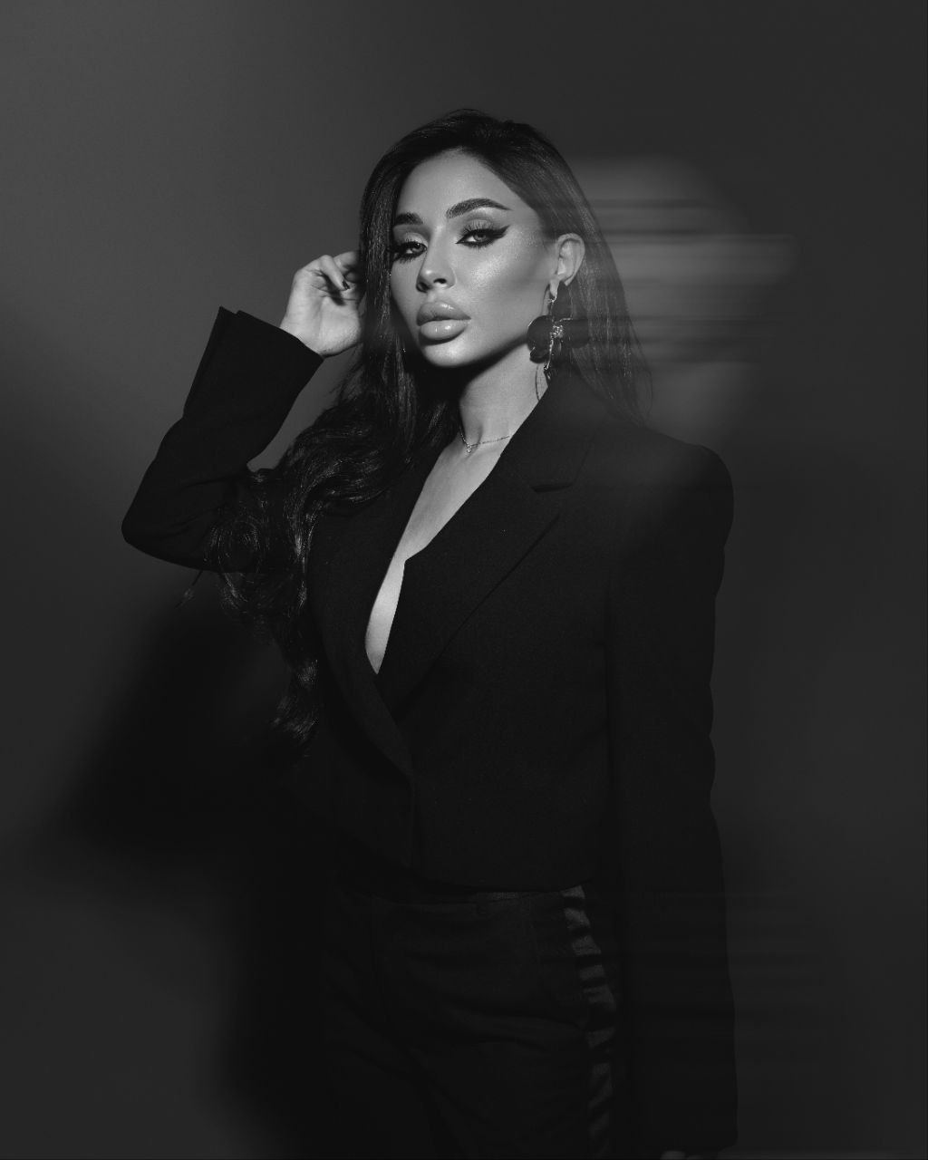 Black and white studio portrait of Zina Almokri in a tailored blazer